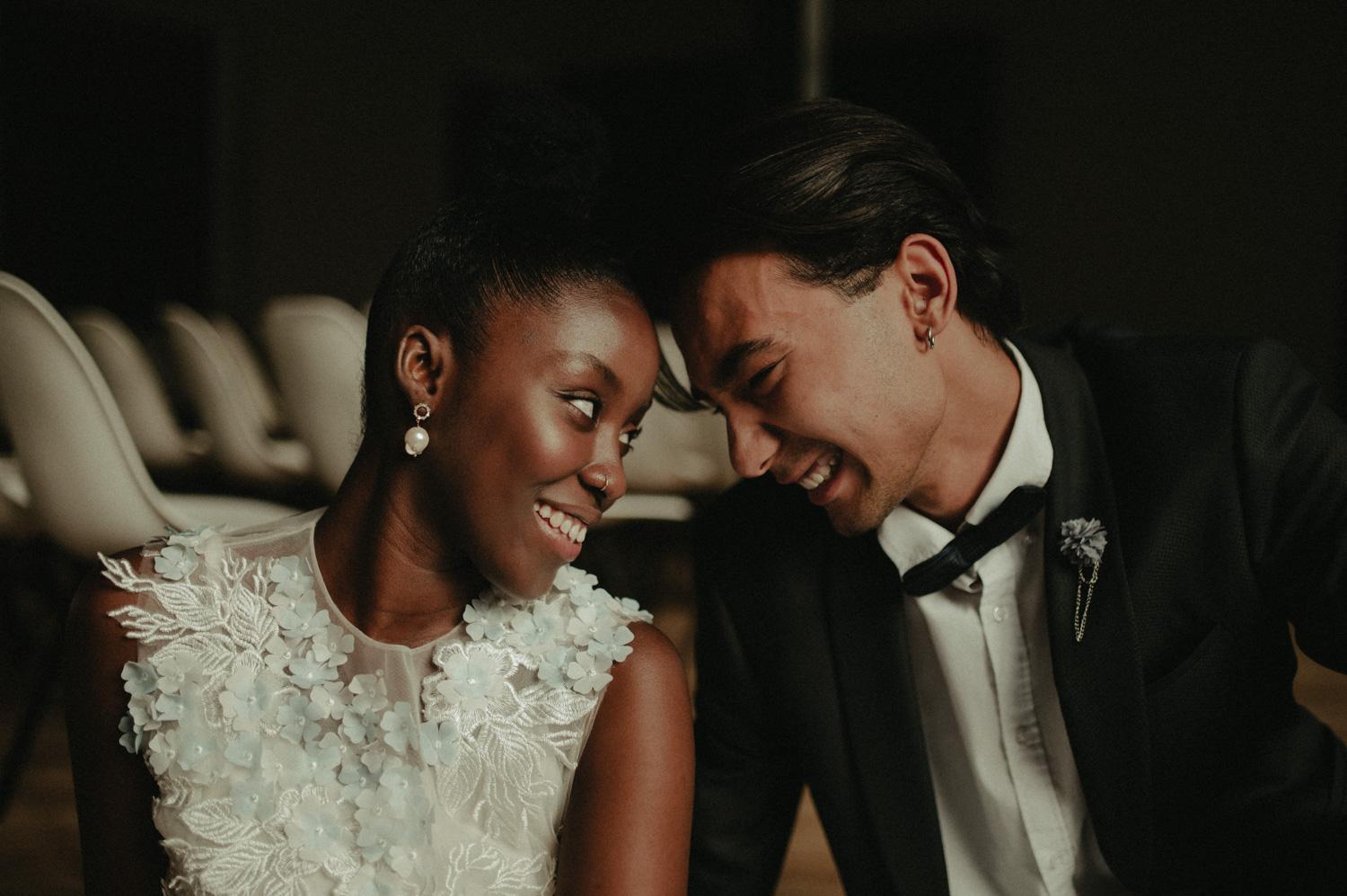 Interracial bride and groom look at each other smile and lock eyes during their destination wedding celebration in Los Angeles, Palm Springs, or San Diego