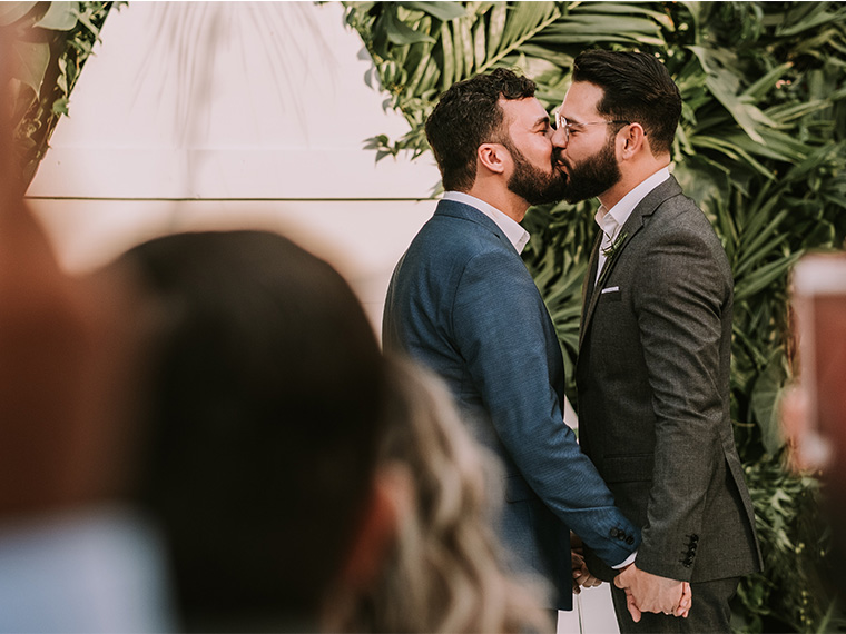 two men in a wedding kissing