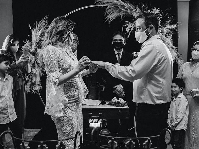 Wedding couple exchanging rings wearing masks